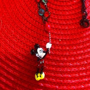 Mickey Mouse holding a balloon necklace.